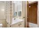 Bathroom featuring a white sink, decorative mirror, and patterned wallpaper at 1315 Elder Way, Burlington, NC 27215