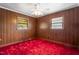 Cozy bedroom featuring paneled walls, bright windows, and a ceiling fan at 1315 Elder Way, Burlington, NC 27215