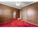 Wood paneled bedroom showcasing a mirrored closet door and red carpet at 1315 Elder Way, Burlington, NC 27215