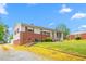Charming single-story home with a brick facade and a well-maintained lawn under a partly cloudy sky at 1315 Elder Way, Burlington, NC 27215