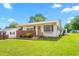 Quaint single-story home featuring a manicured lawn, brick accents, and a welcoming front entrance at 1315 Elder Way, Burlington, NC 27215