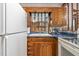 Cozy kitchen featuring wooden cabinetry, blue countertops, and a pass-through window to another room at 1315 Elder Way, Burlington, NC 27215
