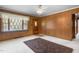 Classic living room featuring paneled walls, vintage lace curtains, and a dark brown area rug at 1315 Elder Way, Burlington, NC 27215