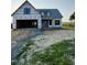 New construction home with an attached two-car garage, front porch, and black window frames at 1327 Parkertown Rd, Four Oaks, NC 27524