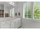 Well-lit bathroom with a double vanity, a large mirror, and a bright window at 145 Cofield Cir, Durham, NC 27707