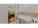 Bathroom with a soaking tub, tiled walls, and access to a bedroom at 145 Cofield Cir, Durham, NC 27707