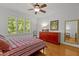 Well-lit bedroom featuring hardwood floors, large window, stylish décor, and a ceiling fan at 145 Cofield Cir, Durham, NC 27707