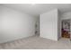 Spacious bedroom featuring neutral carpet, light walls, and open doorway to an adjacent room at 145 Cofield Cir, Durham, NC 27707