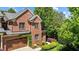 Charming brick home with lush landscaping, wooden garage door, and manicured lawn at 145 Cofield Cir, Durham, NC 27707