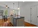 Well-lit kitchen island with sink, pendant lighting, and a view into the sitting area at 145 Cofield Cir, Durham, NC 27707