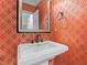 Stylish powder room featuring patterned wallpaper, a pedestal sink, and a decorative mirror at 145 Cofield Cir, Durham, NC 27707