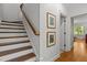 Traditional staircase with wooden steps, white risers, and wall art at 145 Cofield Cir, Durham, NC 27707