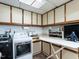 Functional laundry room with washer, dryer, cabinets, sink, and ironing board at 1512 St. Mary'S St, Raleigh, NC 27608