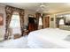 Comfortable bedroom featuring floral curtains, ceiling fan, dresser, and closet with mirrored doors at 1512 St. Mary'S St, Raleigh, NC 27608