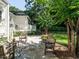 Charming stone patio with wood furniture and lush landscaping adjacent to the home's deck at 1512 St. Mary'S St, Raleigh, NC 27608