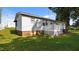 Angled rear view of the home featuring small deck and steps down to grassy backyard at 163 Lake Latham Rd, Mebane, NC 27302