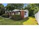 Side angle showing the brick and siding detail of this cozy home with well-maintained landscaping at 163 Lake Latham Rd, Mebane, NC 27302