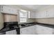 Functional kitchen with white cabinets, modern sink, and black electric range, ready for any home chef at 163 Lake Latham Rd, Mebane, NC 27302