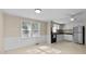 Well-lit kitchen with white cabinets, standard appliances, and ample natural light from the windows at 163 Lake Latham Rd, Mebane, NC 27302