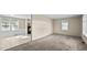 Bright living room with new carpet, neutral walls, and natural light shining through the large windows at 163 Lake Latham Rd, Mebane, NC 27302