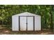 Backyard shed featuring white exterior and opening doors, surrounded by trees at 163 Lake Latham Rd, Mebane, NC 27302