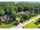 Aerial view of a brick home featuring manicured landscaping, mature trees, and neighborhood street at 164 Avocet Ln, Clayton, NC 27520