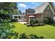 Backyard featuring a brick home with a covered patio, outdoor kitchen, and lush green lawn at 164 Avocet Ln, Clayton, NC 27520