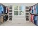 Well-organized walk-in closet with shelves and a bench seat under a sunny window at 164 Avocet Ln, Clayton, NC 27520