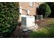 A home's exterior view features a generator, AC units, brick and green leafy bushes at 164 Avocet Ln, Clayton, NC 27520