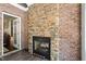 Living room brick fireplace with hearth, wood flooring, and an open doorframe leading into another room at 164 Avocet Ln, Clayton, NC 27520