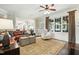Bright living room featuring a large leather sofa, decorative rug, and natural light from an array of large windows at 164 Avocet Ln, Clayton, NC 27520