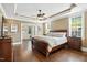 Comfortable main bedroom with hardwood floors, tray ceiling, a walk-in closet, and custom wood furniture at 164 Avocet Ln, Clayton, NC 27520