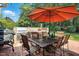 Outdoor kitchen area with a built-in grill, dining table, and chairs on a brick patio at 164 Avocet Ln, Clayton, NC 27520