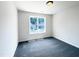 A bright bedroom features neutral walls, gray carpeting, and a window for natural light at 17 Ballard Ct, Durham, NC 27712