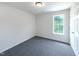 A bright bedroom features neutral walls, gray carpeting, and a window for natural light at 17 Ballard Ct, Durham, NC 27712