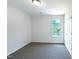 A bright bedroom features neutral walls, brown carpeting, and a window for natural light at 17 Ballard Ct, Durham, NC 27712