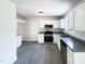 Well-lit kitchen features white cabinets, stainless steel appliances, and granite countertops at 17 Ballard Ct, Durham, NC 27712