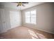 A well-lit bedroom featuring a double door closet and neutral wall paint at 19 Cheltenham Dr, Clayton, NC 27520