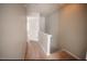 Carpeted hallway leading to a doorway with a white door and neutral walls at 19 Cheltenham Dr, Clayton, NC 27520