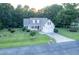 Aerial view of a light yellow house with a large yard and mature trees at 237 Water Front Ln, Timberlake, NC 27583