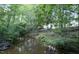 Wooded backyard featuring mature trees and a creek running through the landscape at 237 Water Front Ln, Timberlake, NC 27583