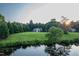 Scenic view of the home across a large grassy yard with a pond nearby at 237 Water Front Ln, Timberlake, NC 27583