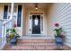Inviting front entry featuring a black door with glass insert and decorative flower pots at 237 Water Front Ln, Timberlake, NC 27583