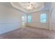 Bright main bedroom with tray ceiling, ceiling fan, neutral carpet and attached bathroom at 237 Water Front Ln, Timberlake, NC 27583