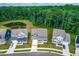 Aerial view of home on a verdant lot surrounded by mature trees and a serene pond at 2720 Spotted Coral Ct, Apex, NC 27502