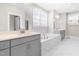 Bright bathroom with double vanity, marble tile, large mirror, and soaking tub at 2720 Spotted Coral Ct, Apex, NC 27502