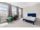 Bright bedroom featuring three large windows, carpet, and a striking blue bed at 2720 Spotted Coral Ct, Apex, NC 27502