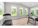Bright bonus room featuring a treadmill, air hockey table, and large windows at 2720 Spotted Coral Ct, Apex, NC 27502
