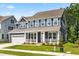 Charming two-story home featuring blue siding, a welcoming front porch, and a convenient attached two-car garage at 2720 Spotted Coral Ct, Apex, NC 27502