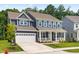 Charming two-story home featuring blue siding, a welcoming front porch, and a convenient attached two-car garage at 2720 Spotted Coral Ct, Apex, NC 27502